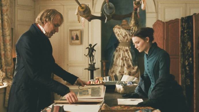 Rhys Ifans (Monsieur Lheureux) en Mia Wasikowska (Emma Bovary)